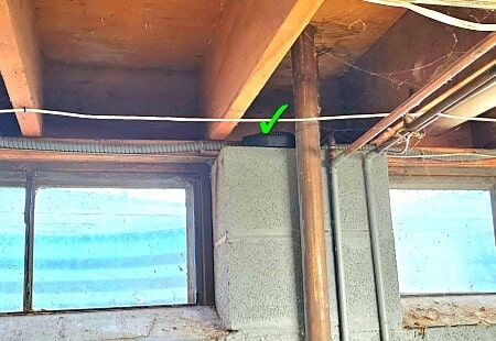 Mouse bait station on top of foundation wall in basement.